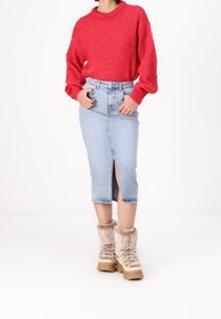 Röd texturerad tröja, ljusblå denim kjol med spetsframtill och beiga stövlar med fuskpälsfoder och kraftig sula.