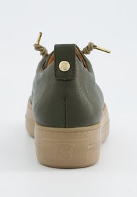 Sneaker en cuir vert olive avec une surface texturée, semelle plateforme beige et accents en doré sur le talon et les lacets.