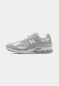 Light gray New Balance 2002R sneaker features a suede and mesh upper, white accents, cushioned sole, and visible cushioning technology.