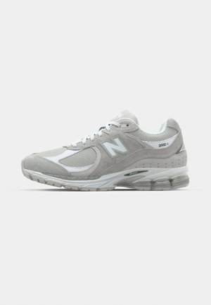 Light gray New Balance 2002R sneaker features a suede and mesh upper, white accents, cushioned sole, and visible cushioning technology.