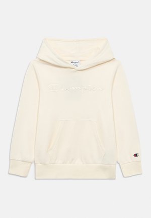 Kremfarget Champion-hettegenser med frontlomme, brodert logo på brystet og liten logo på venstre ermekant.