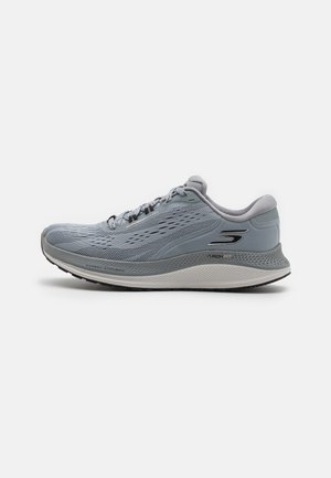 Light grey athletic shoe with a breathable mesh upper, textured midsole, reinforced heel, and black rubber outsole. Features laces and logo.