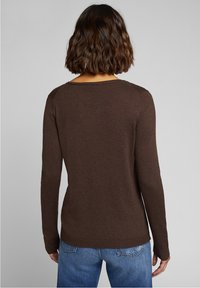 Brązowy sweter z długim rękawem, okrągłym dekoltem i prążkowanym wykończeniem, charakteryzujący się miękką teksturą i dopasowanym krojem, widoczny z tyłu.