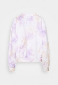 Mjuk bomullströja med lila och beige batikmönster, långa ärmar samt ribbstickade muddar och midjeband, sedd bakifrån.