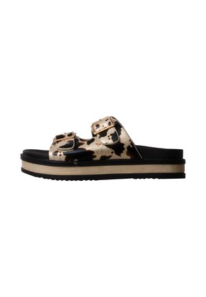 Sandalia de plataforma con tiras de estampado de vaca en negro y beige y hebillas doradas, plantilla negra y suela beige y negra.