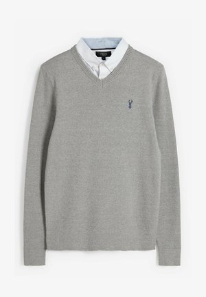 Grijze gebreide trui met een V-hals, met een blauw kreeftenlogo, gedragen over een wit overhemd met blauwe strepen op de kraag.