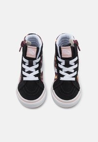 Baskets montantes en daim noir avec un panneau latéral à motif floral, des lacets blancs et un badge en cuir rose. Dotées d'une fermeture éclair pour un enfilage facile.