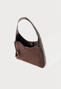 Sac à épaule en daim et cuir marron avec fermeture à pression magnétique, détail de porte-clés et bande unique sur fond blanc.