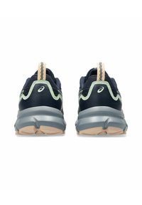 Zapatos de correr de color marino con acentos verde claro, cuello acolchado, parte superior de malla texturizada, mediopié grueso gris y suela beige.
