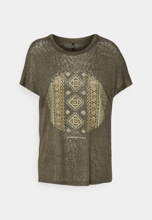 Krótka, oliwkowozielona, przezroczysta koszulka z krótkim rękawem, okrągłym dekoltem i centralnym geometrycznym motywem tribal w złotych i beżowych tonach.