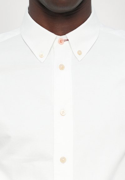 White, button-up shirt with a spread collar. Features four buttons in varying pastel colors on the placket. Fabric is smooth with a slight sheen.