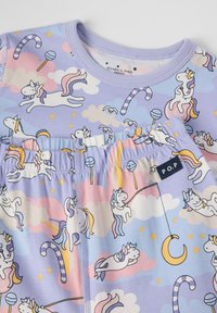 Paarse katoenen top met een eenhoornpatroon, wolken, snoepstokken en sterren. Elastische tailleband met een "P.O.P" label aan de naad.