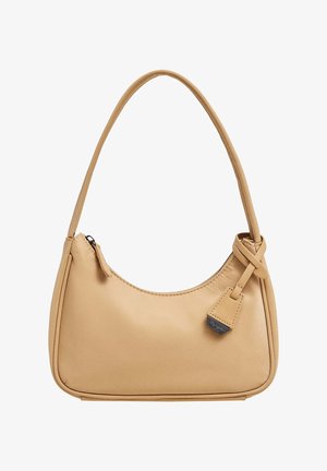 Beige värinen nahkainen olkalaukku, jossa on yksi kantohihna, vetoketjusuljin ja pieni koristeellinen nahkainen merkki lähellä kahvaköyttä.