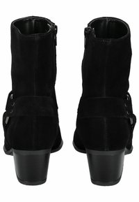Botines de ante negros hasta el tobillo con cierre de cremallera, con una correita ancha que lleva dos botones metálicos decorativos y un tacón bajo de bloque.