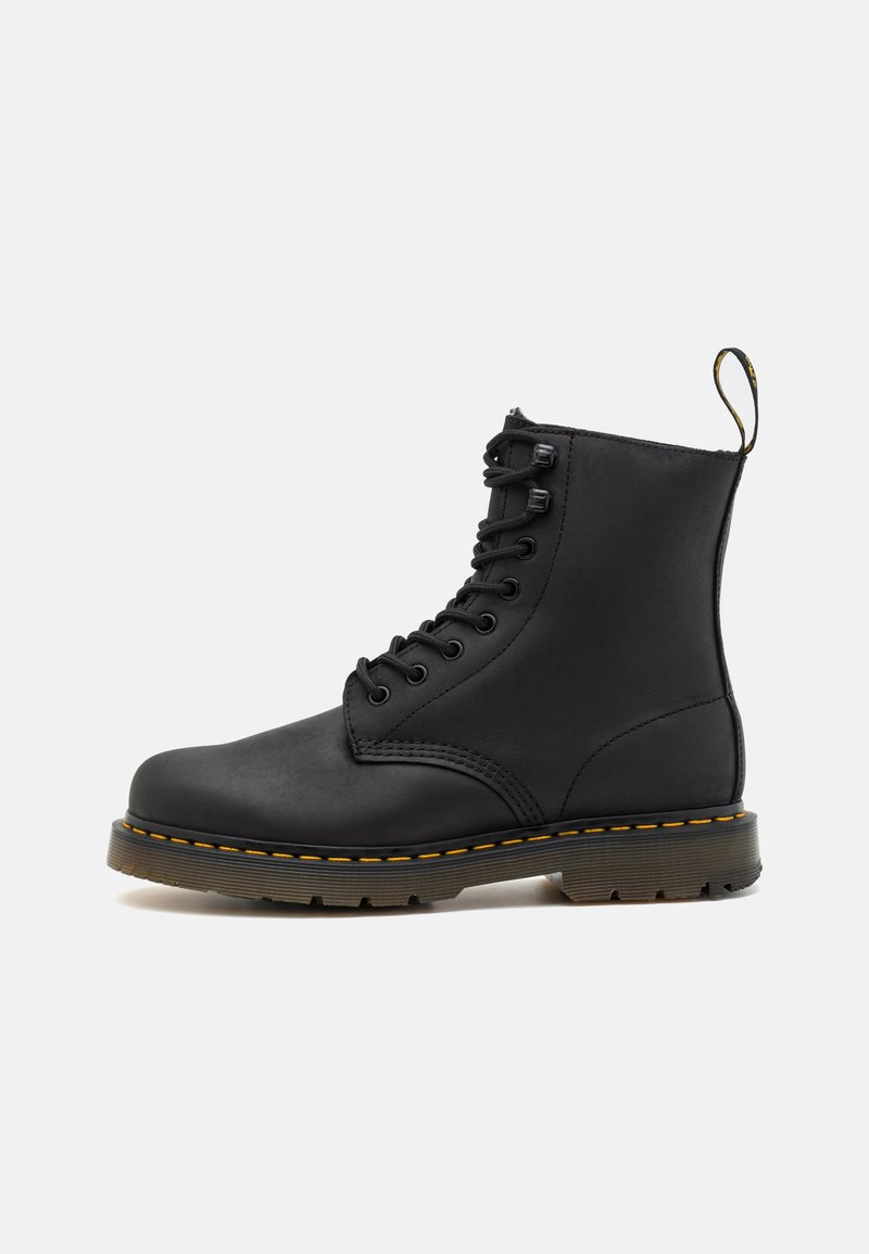 Black leather ankle boot with lace-up front, yellow stitching, round toe, rubber sole, and a pull tab at the back. Smooth texture.