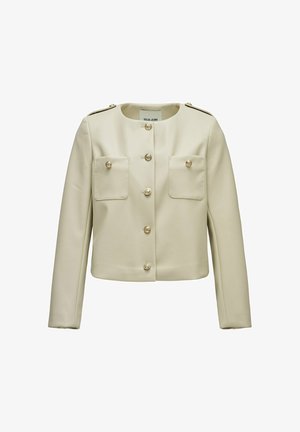 Chaqueta corta de color crema con mangas largas, escote redondo, botones decorativos dorados y dos bolsillos delanteros con solapa.