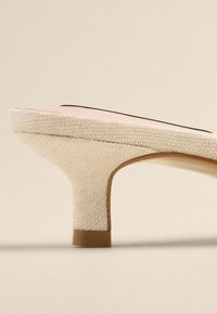 Beige wedge-heel shoe with a woven textile upper, a curved silhouette, a contrasting pink insole, and a rounded base.