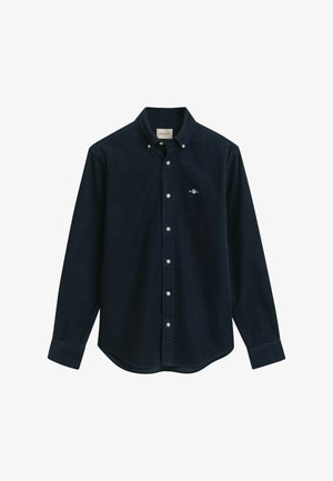 Camisa de botones de un oscuro azul marino, fabricada con una tela texturizada, que presenta un cuello clásico, mangas largas y un pequeño logo bordado en el pecho.