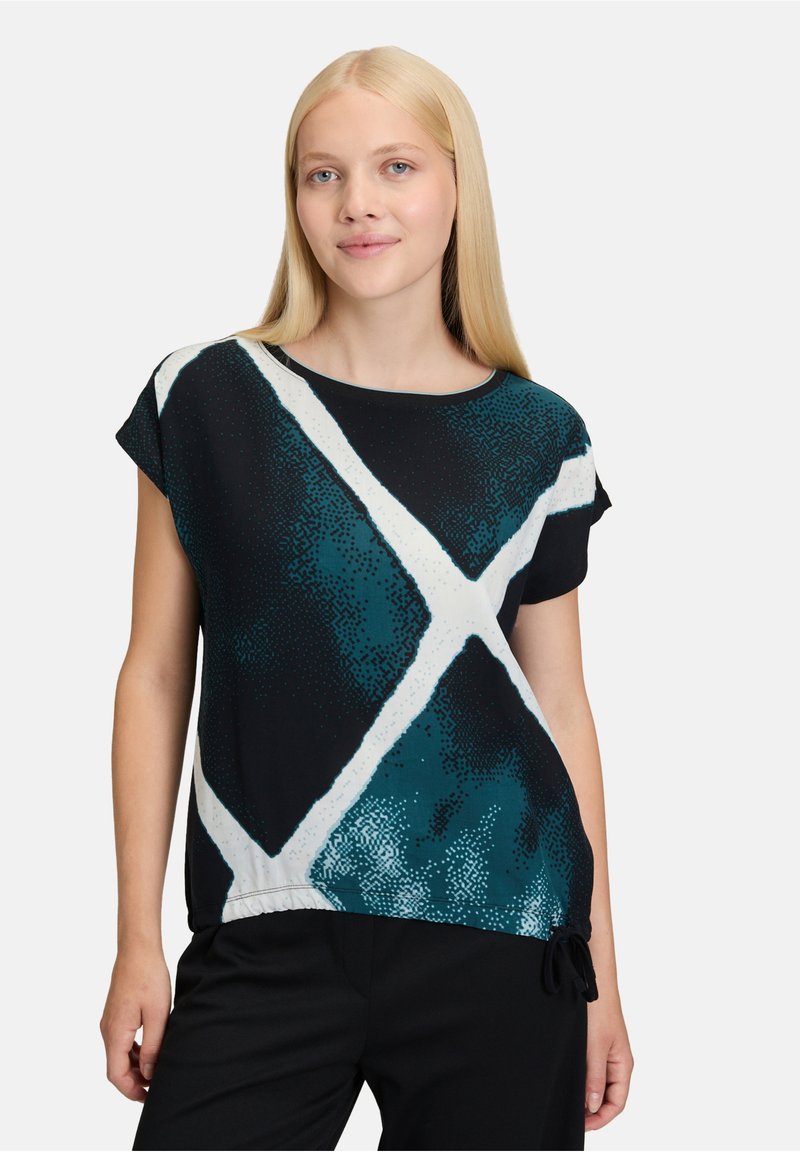 Svart och teal-mönstrad topp med korta ärmar, båtformat halsringning och dragsko detaljer i fåll. Har kontrasterande vita diagonala linjer.