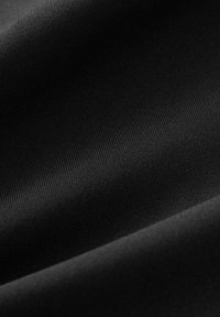 Tissu noir avec une texture lisse et mate, arborant des motifs subtils en relief. Le matériau semble doux et légèrement réfléchissant par endroits.