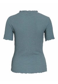Top a maniche corte in tessuto blu morbido e texturizzato. Presenta un collo a vista ondulato e un design aderente che valorizza la forma e la silhouette complessive.