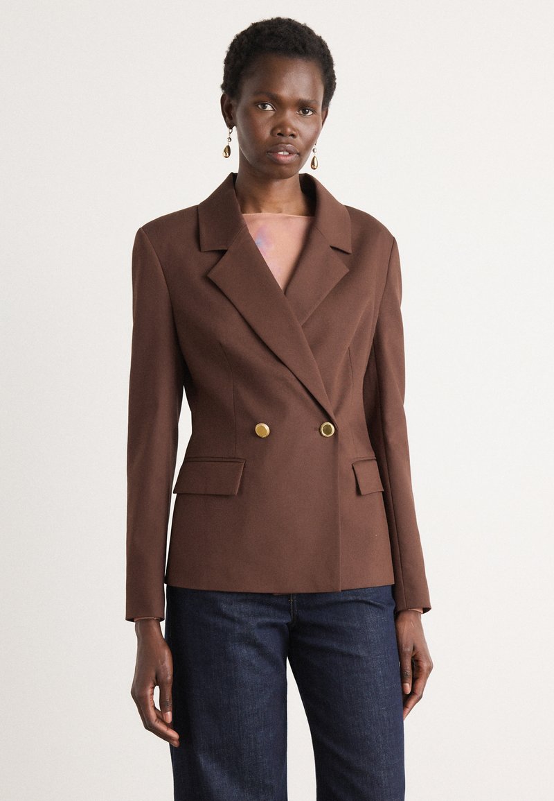 Brun dobbeltspent blazer laget av teksturert stoff, med en skarp krage, to frontlommer og detaljer med gullfargede knapper.