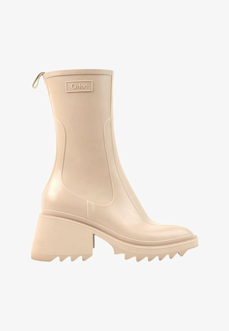 Botte beige mi-mollet à talon épais, semelle rainurée, languette à l'arrière et écusson logo Chloé sur le côté supérieur.