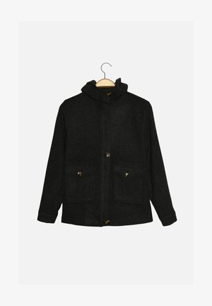 Černá bunda s kapucí z texturované látky, se dvěma předními kapsami a zlatými knoflíky jako ozdobou. Má zapínání po celé přední straně a volný střih.