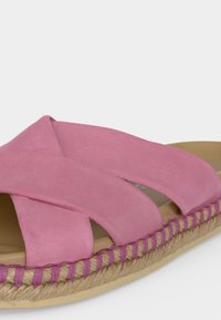 Sandales en daim rose avec larges brides croisées et semelle style espadrille cousue avec corde sur une semelle intérieure beige.