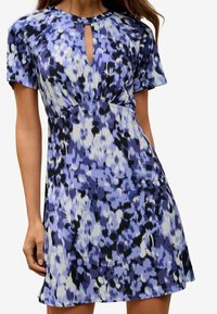 Abito a maniche corte in tonalità di blu, nero e bianco con scollatura a chiave e dettaglio in vita arricciato. Tessuto morbido e leggero con motivo floreale.