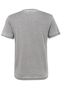 Harmaa t-paita pyöreällä kauluksella, lyhyillä hihoilla, pehmeällä pinnalla ja hieman haalistuneella viimeistelyllä. Ei näkyviä logoja tai kuvioita.