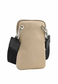 Sac bandoulière beige en tissu doux avec une fermeture éclair, équipé de ferrures argentées et d'une sangle noire réglable. Design carré, texture lisse.