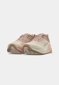 Sapatos de corrida leves com parte superior creme e detalhes em rosa, apresentando uma superfície texturizada, design respirável e sola Vibram.