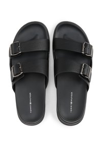 Black slide sandals featuring two wide straps with textured surfaces and metallic buckles, on a smooth black sole. Logo printed on footbed.