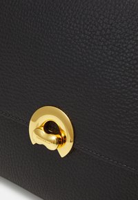 Borsa a tracolla in pelle nera testurizzata con chiusura e dettagli metallici dorati. Il design presenta dettagli cuciti e un meccanismo di chiusura arrotondato.