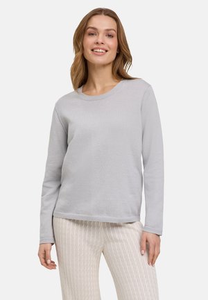 Maglione grigio chiaro a maniche lunghe con scollatura rotonda e texture morbida, abbinato a pantaloni ribbed color crema con motivo a treccia.