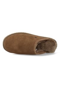 Bruine suede pantoffel met een afgeronde neus, open achterkant en een zachte binnenvoering. Voorzien van een gestructureerde rubberen zool en een metalen logoaccent.