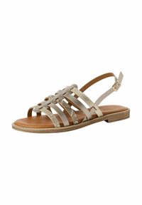 Beige flat sandal with multiple crisscross straps, a textured finish, and a brown sole. Features adjustable ankle strap and detailed accents.