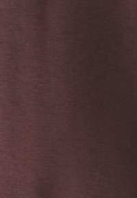 Bordeauxkleurige stof met een gladde textuur en subtiele glans, met een consistente, effen kleur en lichte variaties in licht.