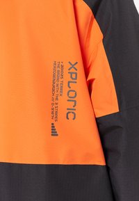 Orange and black textile featuring a logo and text detail in gray. Fabric appears smooth with a matte finish. Includes branding information.