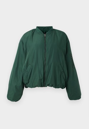 Žalias bomberio švarkas su užtrauktuku priekyje, raukšlėtu apykakle ir šoniniais kišenėmis. Pasižymi trumpa siluetu ir lygiu audinio paviršiumi.