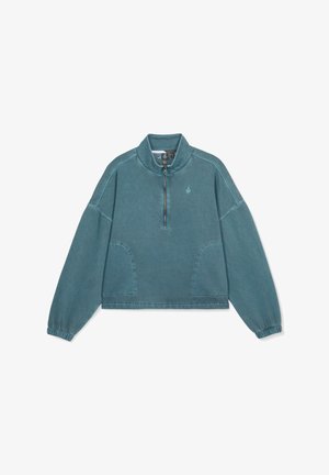 Miękka, turkusowa bluza z krótkim zamkiem na szyi, z elastycznymi mankietami i bocznymi kieszeniami. Posiada szwy stębnowane oraz małe logo na klatce piersiowej.