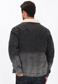 Átmenetes szürke farmerdzseki bézs műbőr szőrme gallérral, klasszikus szabású és standard gombos mandzsettákkal.