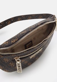 Ciemnobrązowa skórzana torba na ramię z wzorzystą powierzchnią, zamkiem błyskawicznym i złotym metalowym wykończeniem. Wnętrze wyłożone gładką podszewką z kieszonką.
