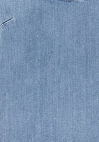 Tissu en denim bleu clair avec une texture lisse, présentant un motif de tissage subtil et un détail de bord non fini.