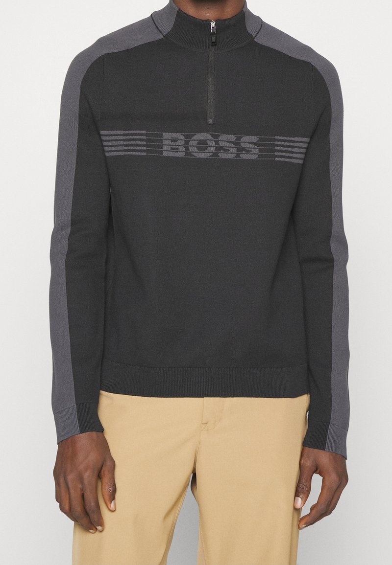 Ciemnoszary sweter dziany z wysokim kołnierzem i półzamkiem. Posiada poziome logo "BOSS" oraz kontrastowe, teksturowane rękawy.