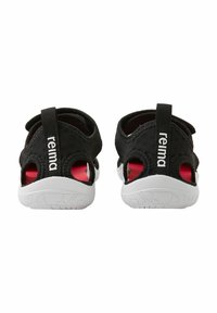 Zapatillas de agua negras con un diseño ligero, lados abiertos y suelas de goma blancas; cuentan con una cinta de agarre y un detalle interior rojo en contraste.