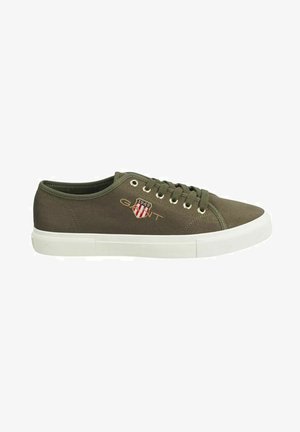 Olive green canvas sneaker with white rubber sole, round toe, and metal eyelets. Features embroidered logo patch on side.