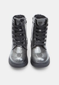 Botines negros brillantes hasta el tobillo con un acabado lustroso, puntera redonda y diseño de cordones, que cuentan con cordones texturizados negros y una cremallera lateral.
