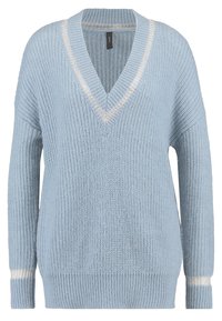 Ljusblå V-ringad tröja i ribbat stickat tyg. Har en avslappnad passform och vita accentremsor vid kragen och ärmarna.